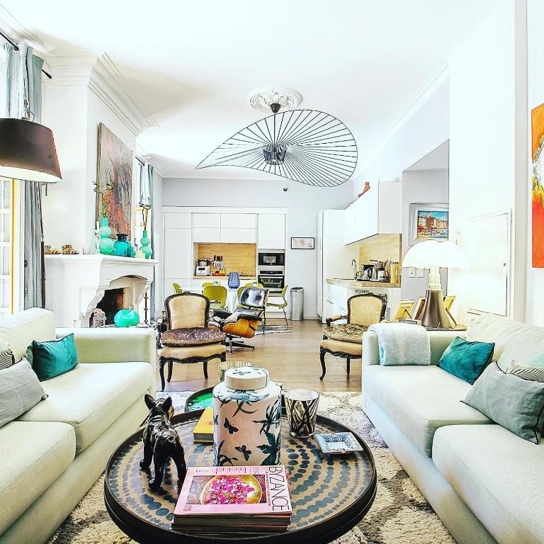 un salon avec deux canapés et une table dans l'établissement Cosy Loft tarif avec 1 ou 2 chambres 2 ou 4 personnes, vue parc et piscine, à Aix-en-Provence