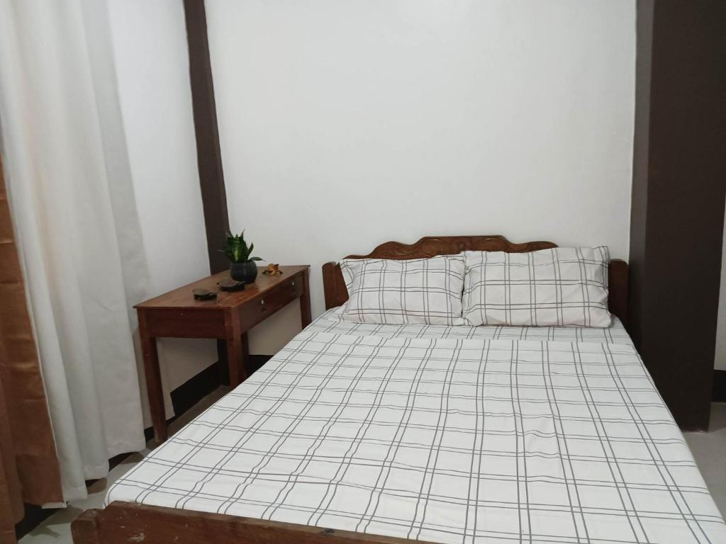 1 dormitorio con 1 cama y 1 mesa con mesita de noche en DGA Pension House, en Corón