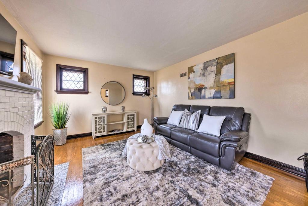 a living room with a leather couch and a fireplace at St Louis Vacation Rental 4 Mi to Airport! in Woodson Terrace