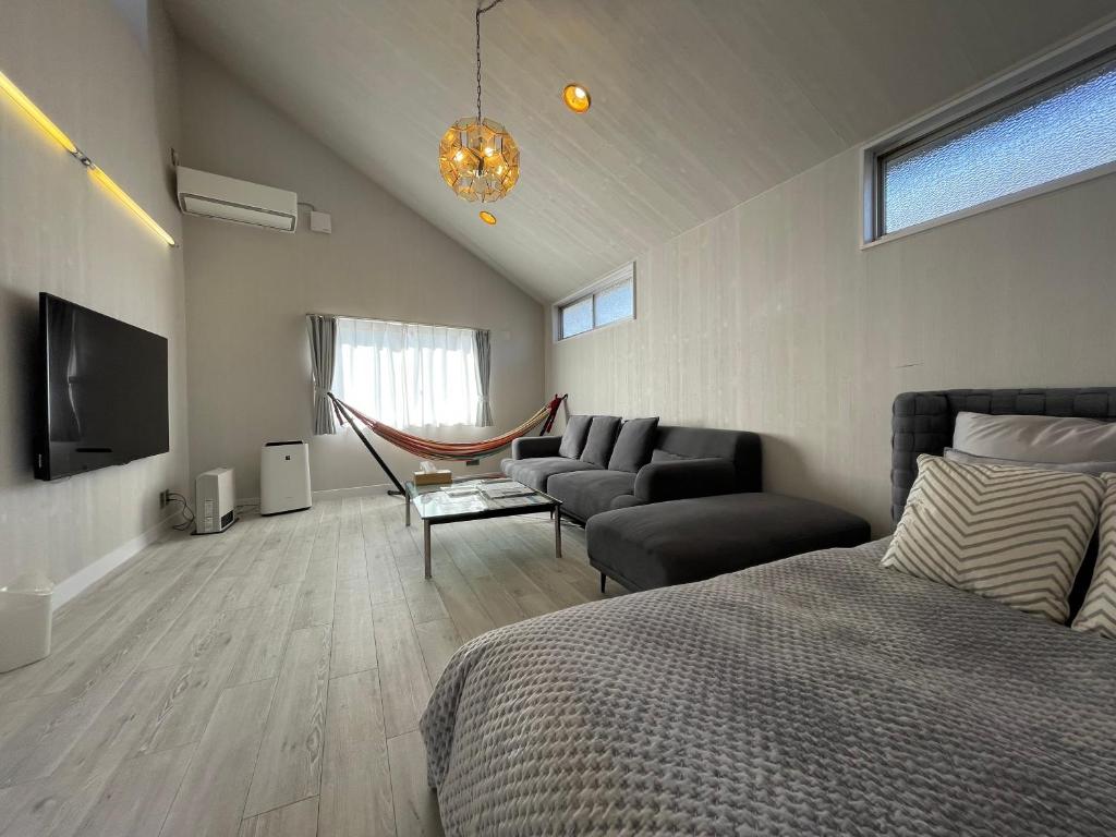 um quarto com uma cama, um sofá e uma televisão em tocoro. Mt. Fuji Hazuki em Fujikawaguchiko