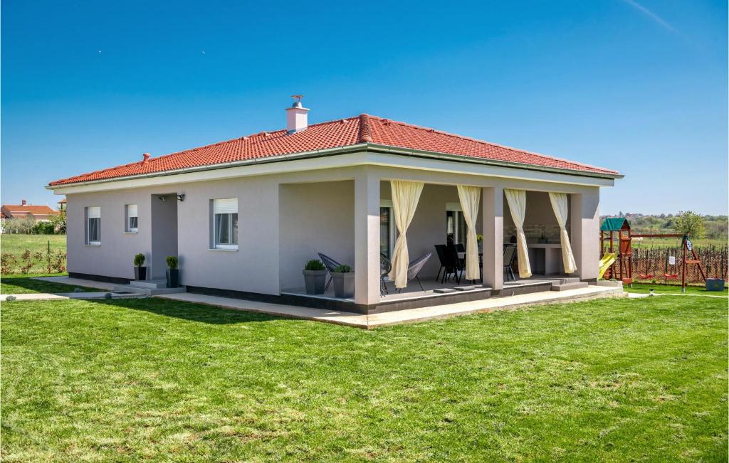 una pequeña casa blanca con cenador en Lovely Home In Radeki Glavica With House A Panoramic View, en Loborika