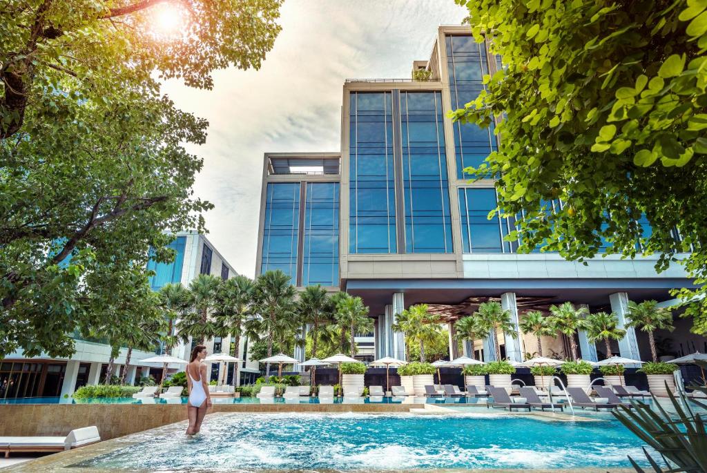 a rendering of a woman standing in a swimming pool at a hotel at Four Seasons Hotel Bangkok at Chao Phraya River in Bangkok