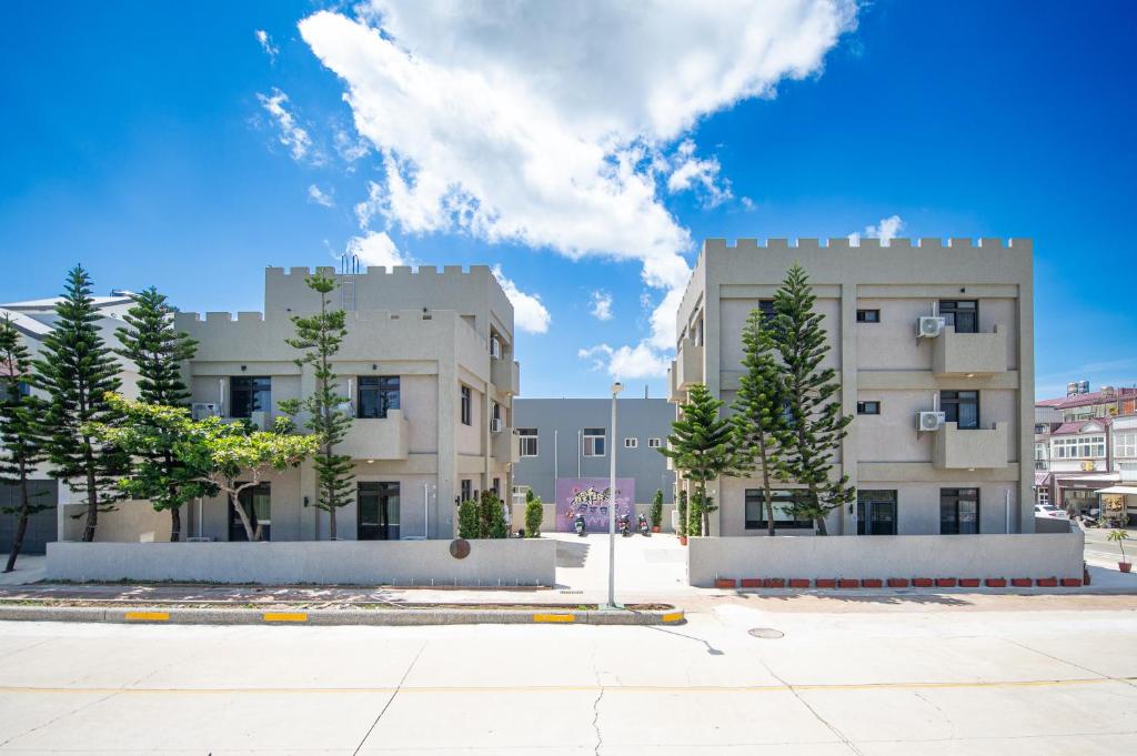 un grand bâtiment avec des arbres devant lui dans l'établissement 尼莫日記民宿, à Huxi