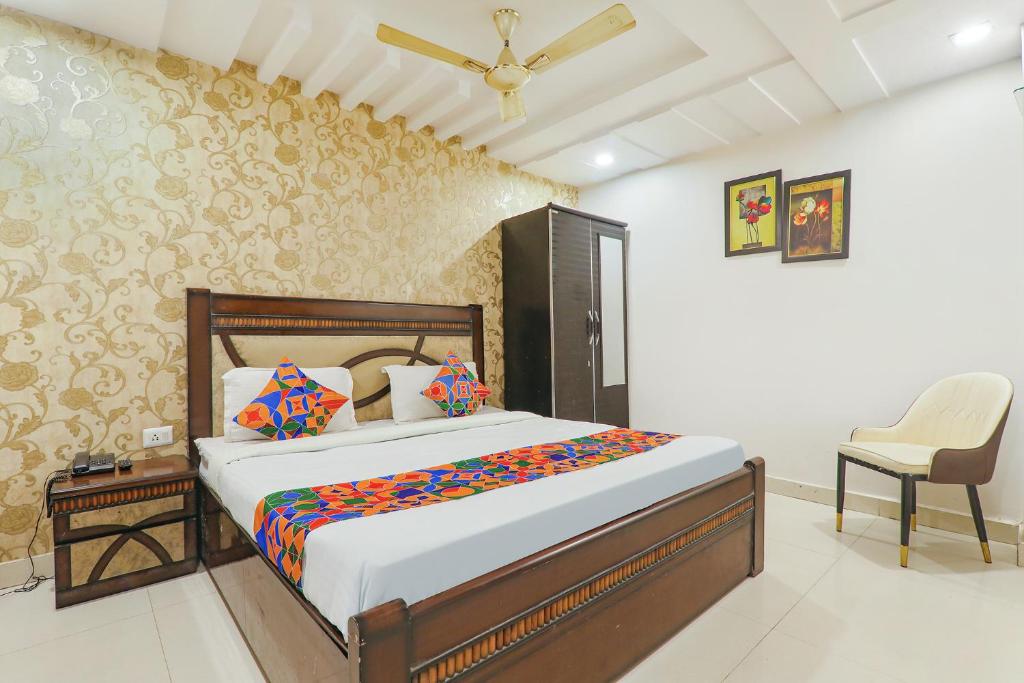 a bedroom with a bed and a chair in it at FabHotel The Villa in Kānpur