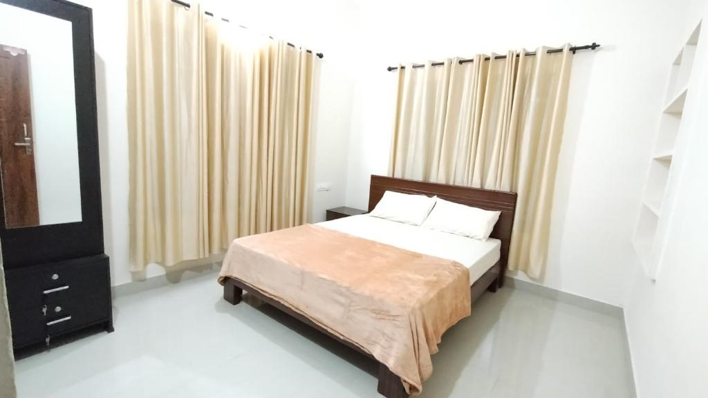 um quarto com uma cama e uma grande janela em Eve's appartment em Meppādi