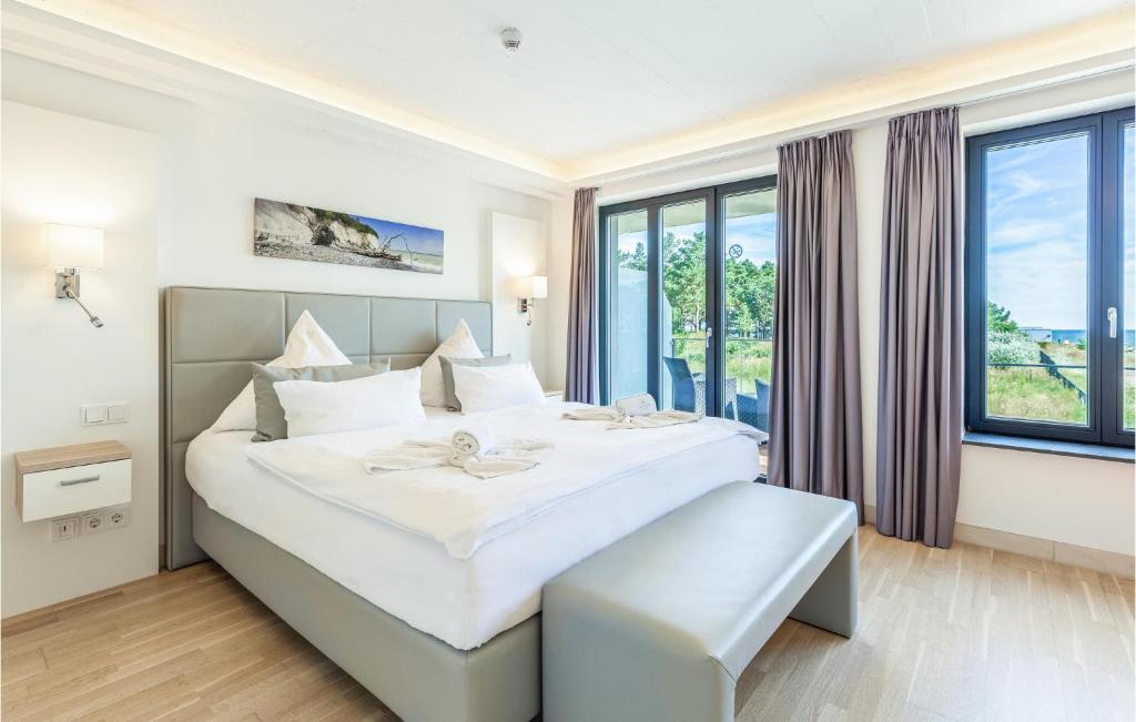a bedroom with a large white bed with a window at Skipper in Binz
