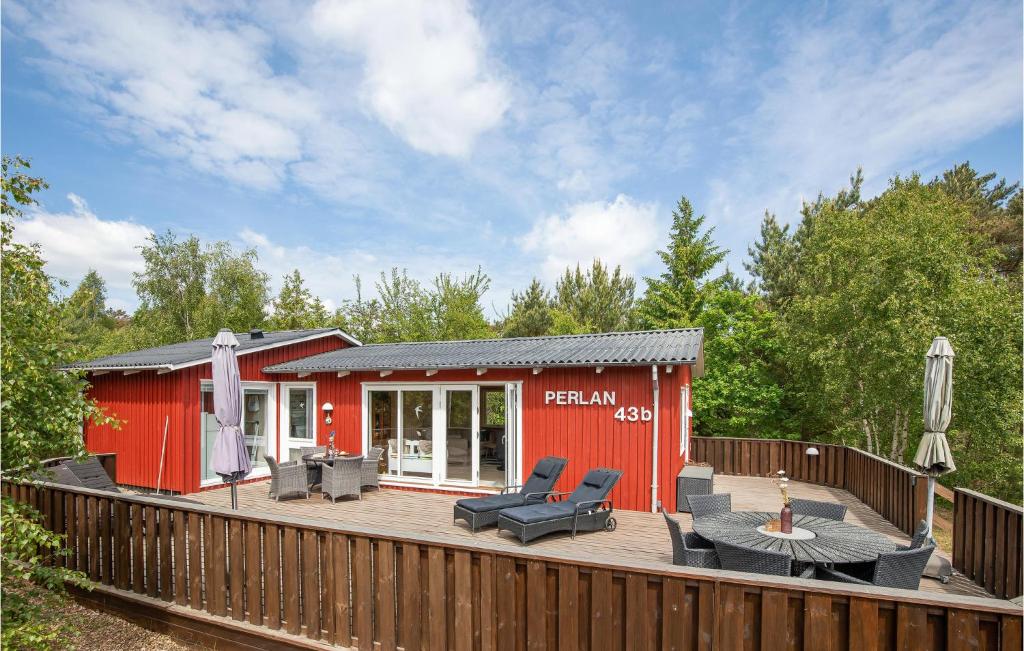 a red tiny house on a wooden deck at Perlan in Snogebæk