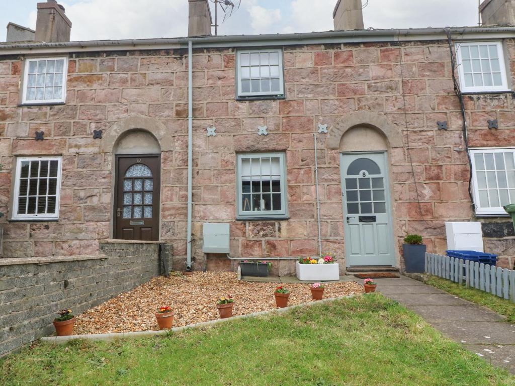 an old brick house with a garden in front of it at Llety Bach in Caernarfon