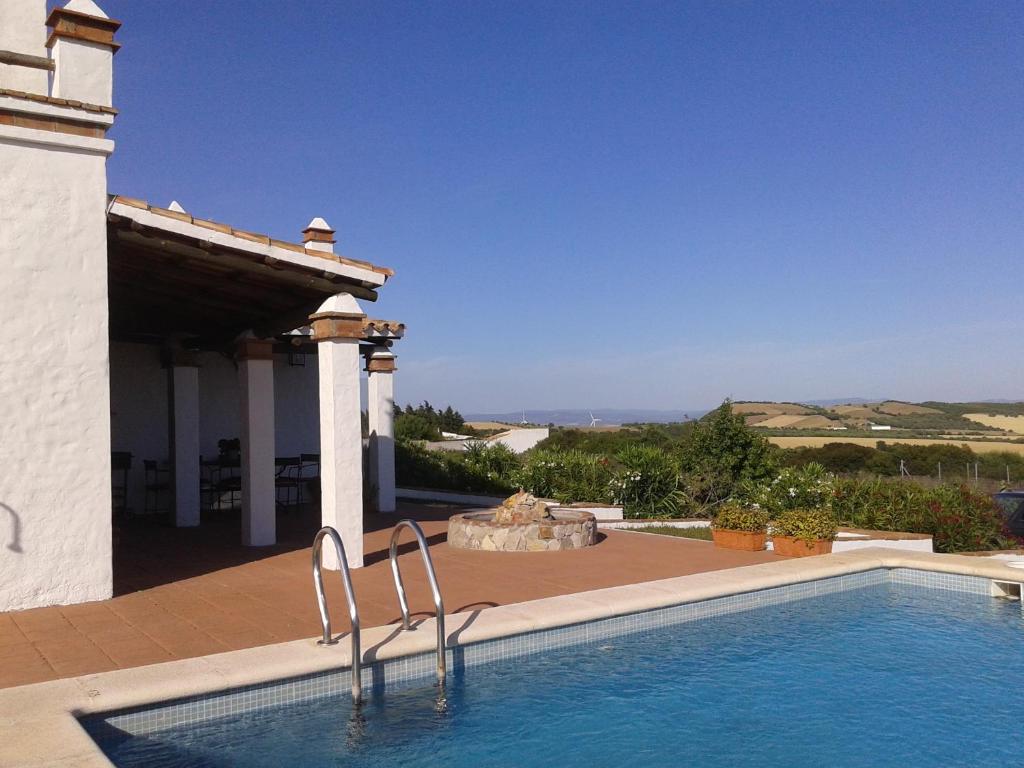 a swimming pool in front of a house at El Matorral Chalet in Vejer de la Frontera
