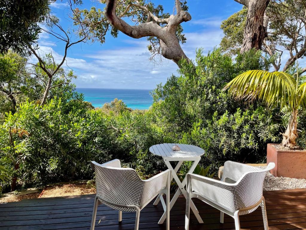 a patio with a table and chairs and the ocean at The Lookout, Eagle Bay in Dunsborough