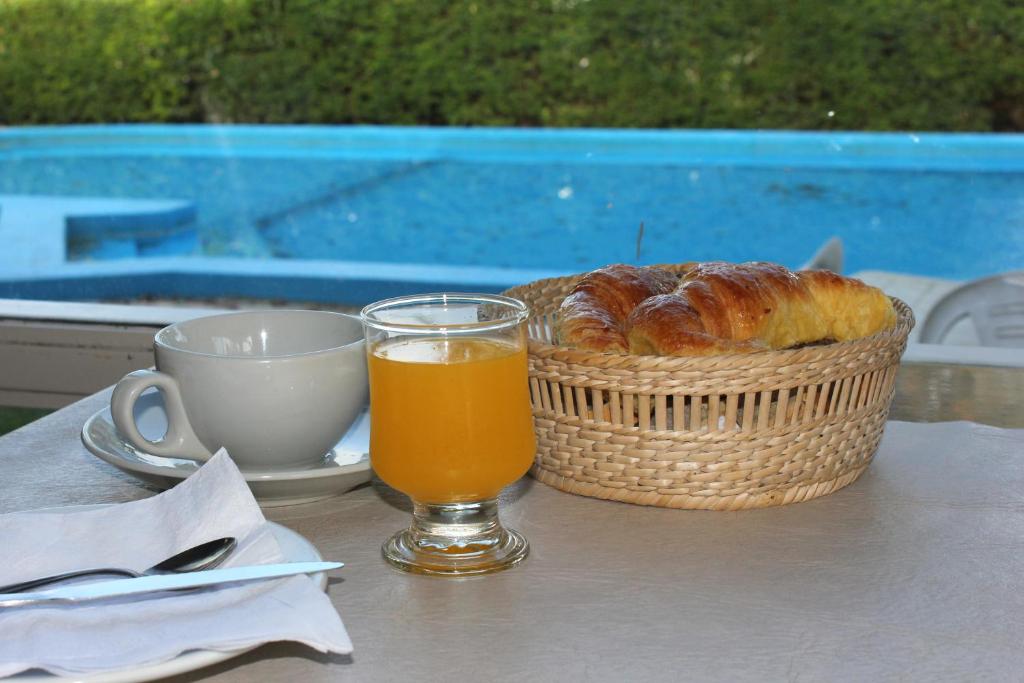 una mesa con una cesta de pan y un vaso de zumo de naranja en Hotel Marydor en La Falda