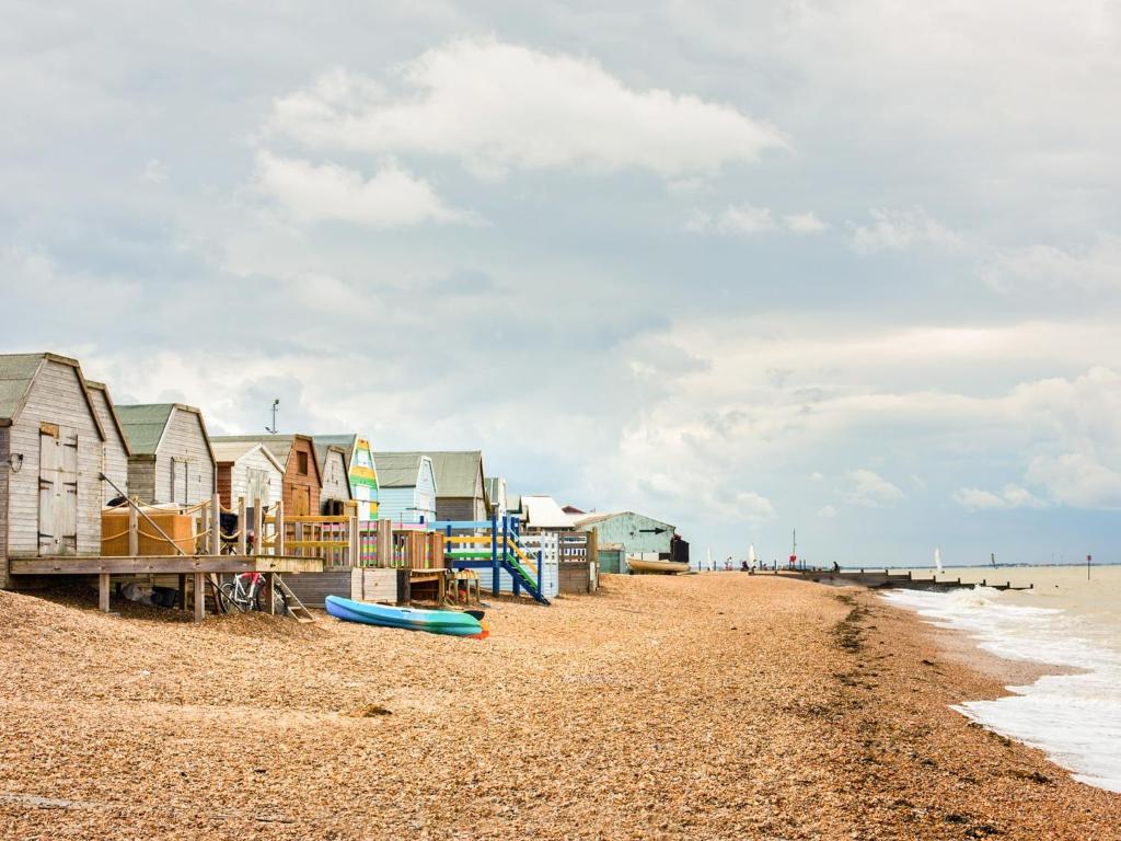 a beach with a row of houses and a pier at Apartment 12 - Uk42743 in Whitstable