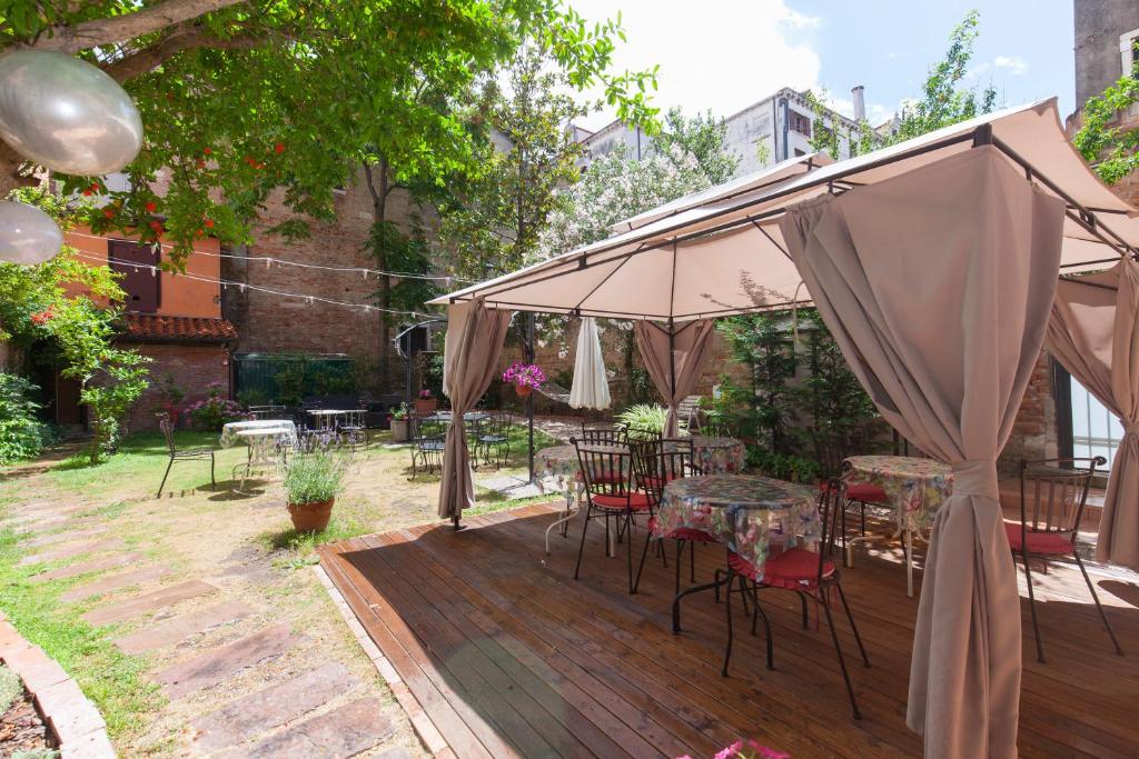 een patio met tafels en stoelen onder een parasol bij Casa Del Melograno in Venetië