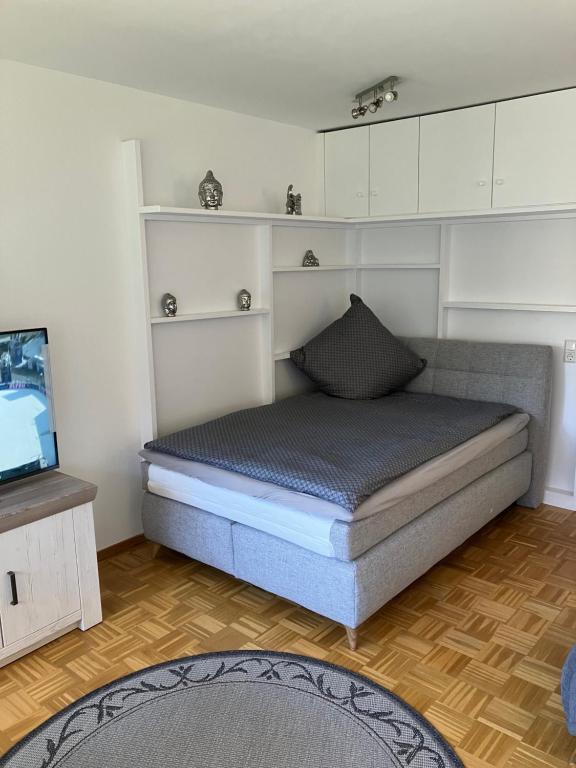 uma pequena cama num quarto com uma televisão em 1 - Zimmer Appartement - kleine Harzperle em Langelsheim