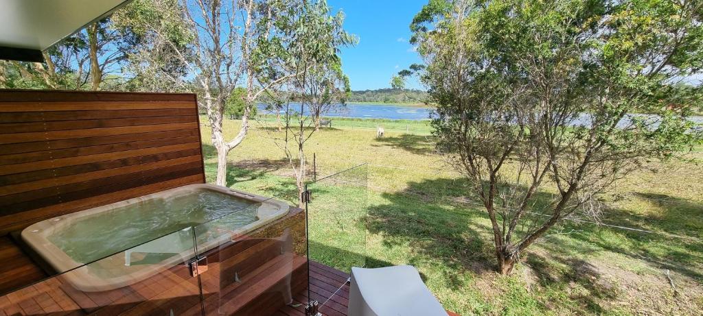 une baignoire sur une terrasse avec vue sur le lac dans l'établissement Narangba Motel (formerly Brisbane North B&B and Winery), à Narangba