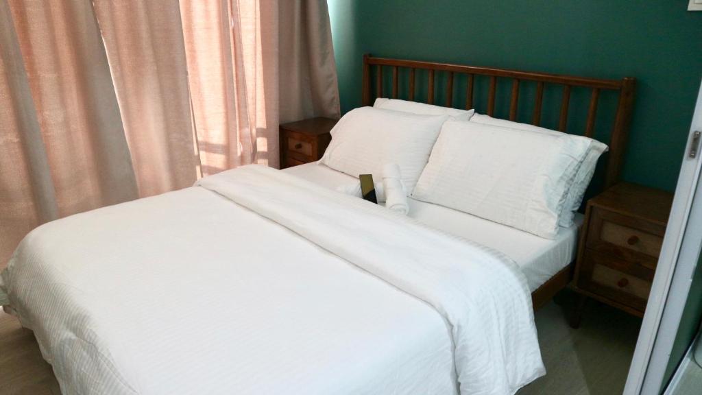 een slaapkamer met een bed met witte lakens en kussens bij Relaxing 1BR Sanctuary at Azure with Wi-Fi in Manilla