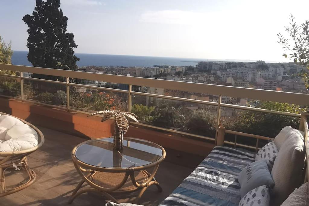 un balcon avec une table et une vue sur l'océan dans l'établissement Appartement Nice CENTRE vue Mer avec piscine pour FAMILLE, couple d'amis pas de groupes de jeunes autorisés, à Nice