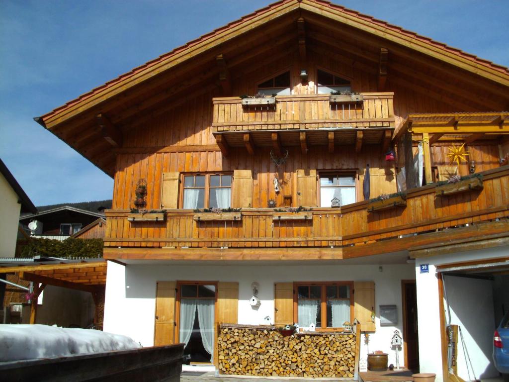a large wooden house with a balcony on top at Ferienwohnung Barbara in Oberammergau