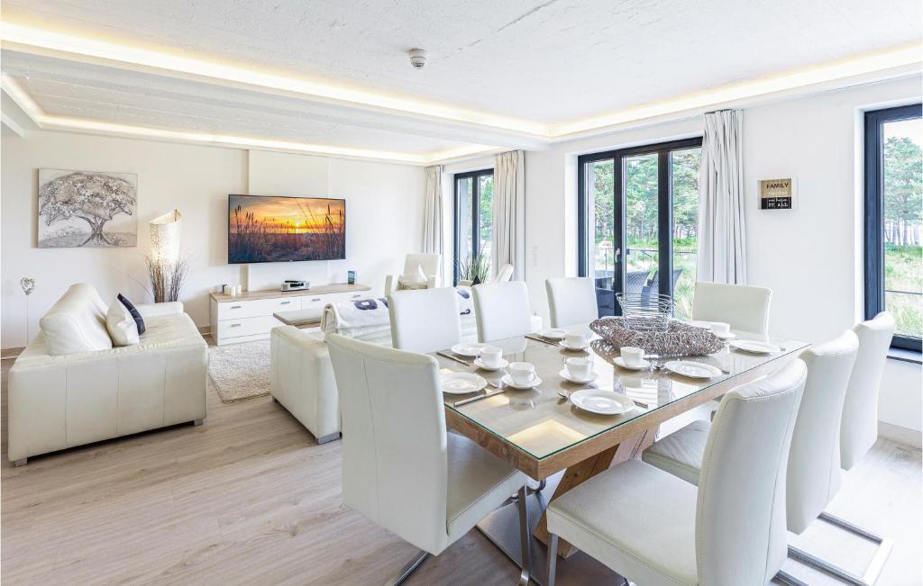 a dining room with a table and white chairs at Captn in Binz