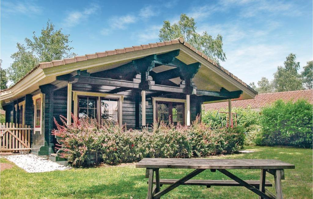 een houten huis met een picknicktafel ervoor bij Amazing Home In Hulshorst With 3 Bedrooms And Wifi in Hulshorst