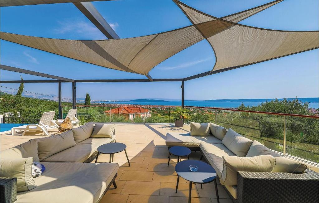 a patio with couches and tables and a view of the ocean at Amazing Home In Kastel Stari With Kitchen in Kastel Novi