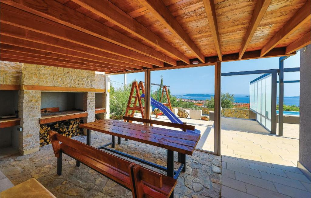 a porch with a wooden bench and a fireplace at Amazing Home In Kastel Stari With Kitchen in Kastel Novi