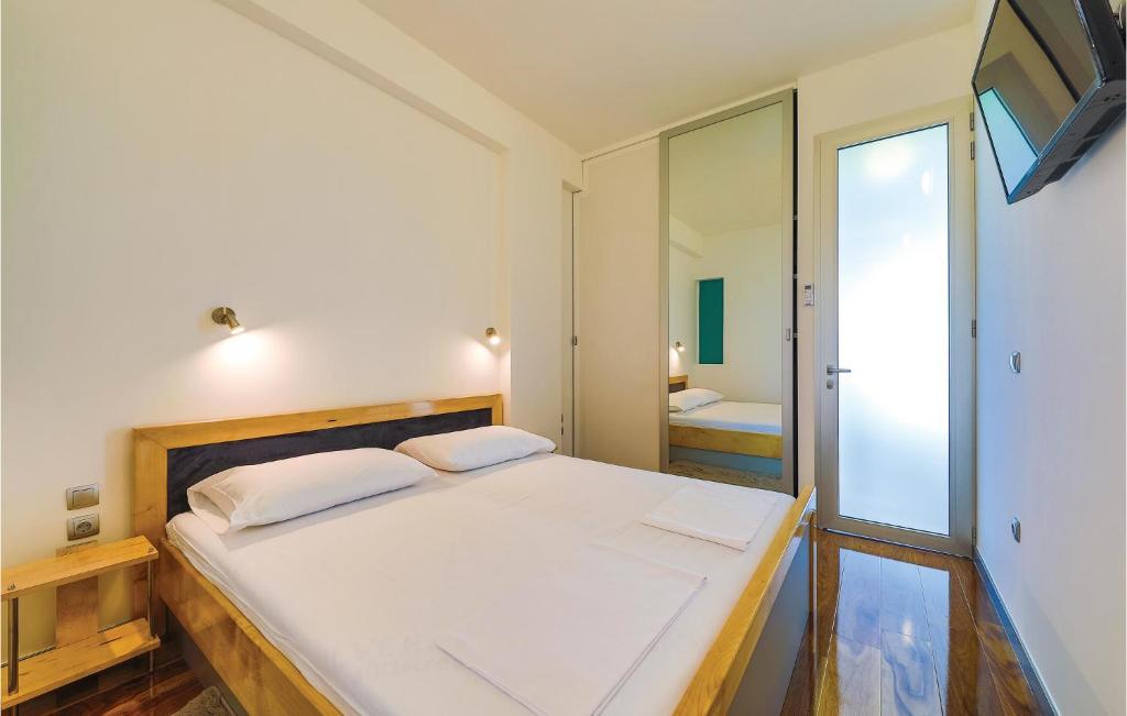 a bedroom with a large white bed and a mirror at Amazing Home In Kastel Stari With Kitchen in Kastel Novi