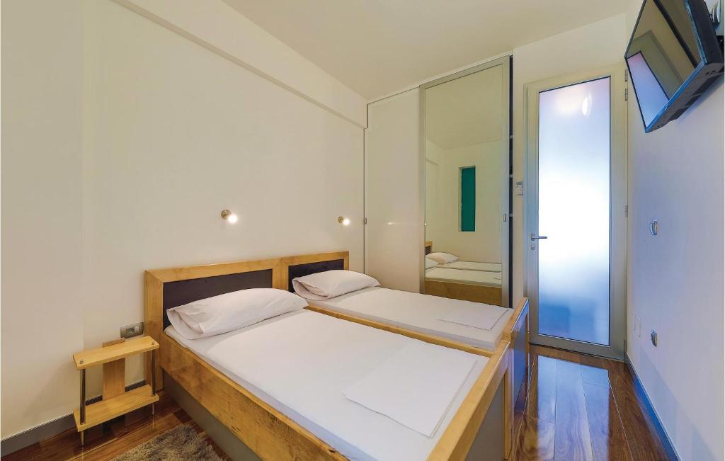 a bedroom with a large bed and a mirror at Amazing Home In Kastel Stari With Kitchen in Kastel Novi