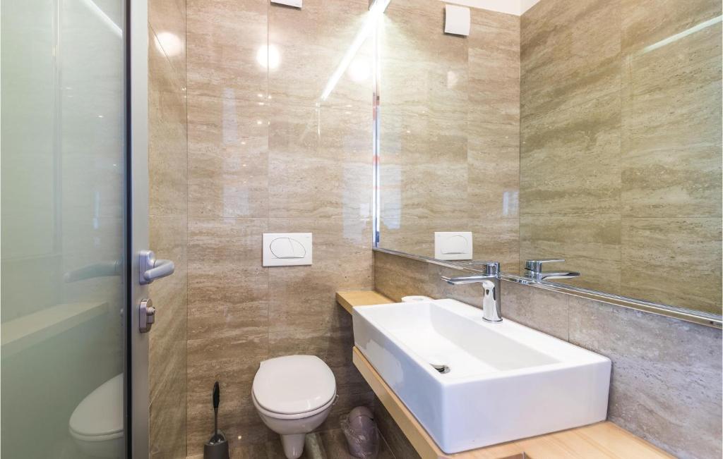 a bathroom with a white sink and a toilet at Amazing Home In Kastel Stari With Kitchen in Kastel Novi