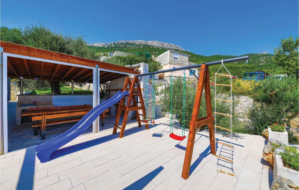 a deck with a slide and a swing set at Amazing Home In Kastel Stari With Kitchen in Kastel Novi