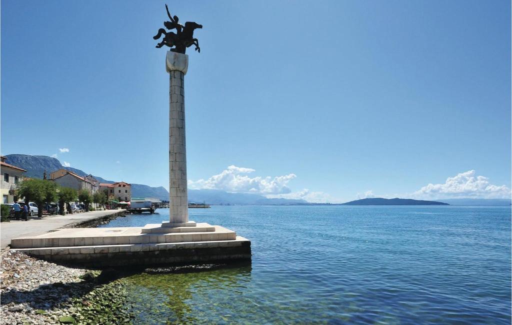 a statue in the middle of a body of water at Amazing Home In Kastel Stari With Kitchen in Kastel Novi