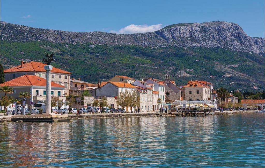 a town on the water with a mountain in the background at Amazing Home In Kastel Stari With Kitchen in Kastel Novi