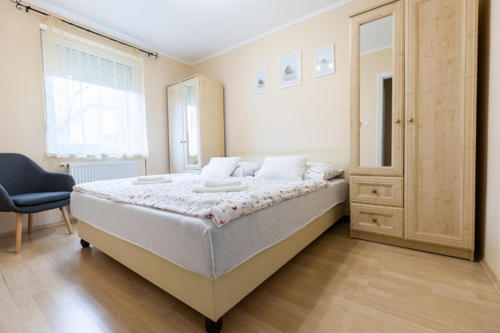 ハイドゥソボスローにあるMárta Apartmanのベッドルーム1室(ベッド1台、椅子、窓付)