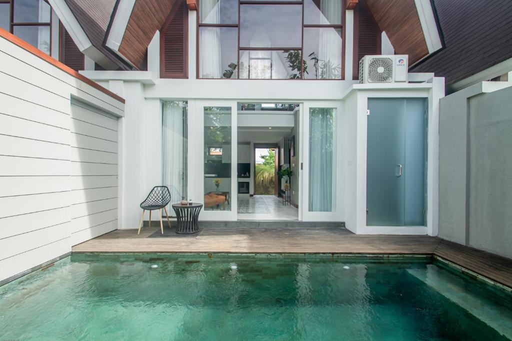 uma casa com piscina em frente a uma casa em Kanhara Villas Ubud by Pramana Villas em Ubud