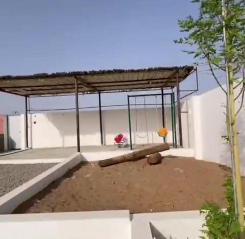 einem Pavillon mit einer Bank vor einem Gebäude in der Unterkunft بيت المقصورة بولاية سناو 