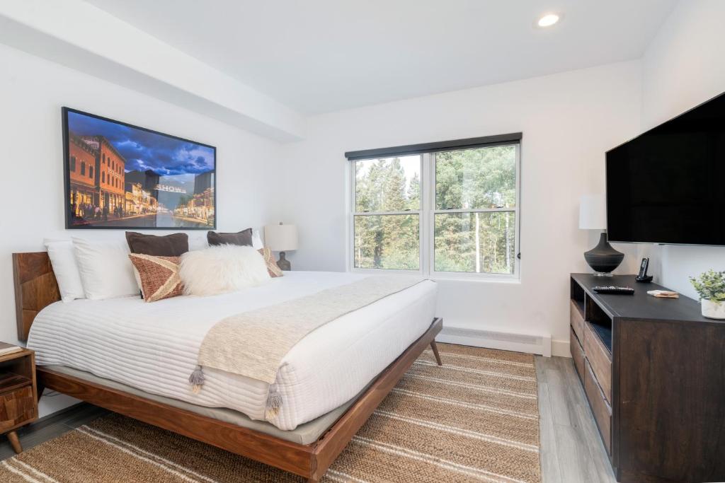 um quarto com uma cama grande e uma televisão de ecrã plano em Bear Creek Lodge 207B Hotel Room em Telluride