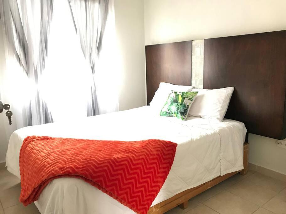 Un dormitorio con una cama grande con una manta roja. en Casa en comarca minera en Acayuca