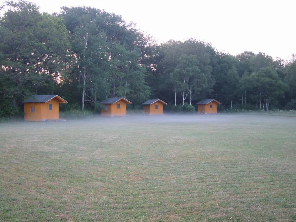 a group of cabins in a field with fog at Kõljala puhkeküla in Kaali
