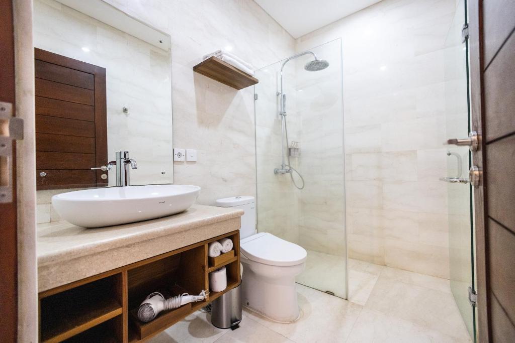 a bathroom with a sink and a toilet and a shower at Tamantara in Ubud