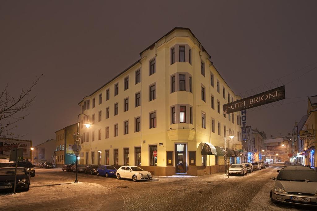 a large white building on a city street at night at Brioni Suites in Ostrava