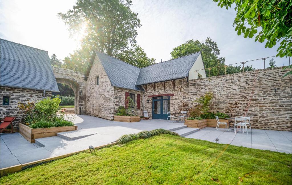 Cette maison en pierre dispose d'une terrasse et d'un mur en pierre. dans l'établissement Beautiful Home In Concarneau With Wifi, à Concarneau