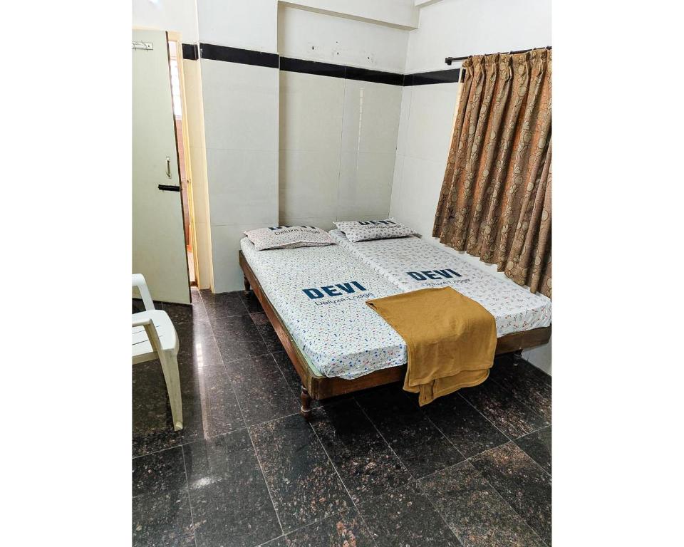 Un dormitorio con una cama con una manta. en Devi Deluxe Lodge By WB Inn, en Secunderābād
