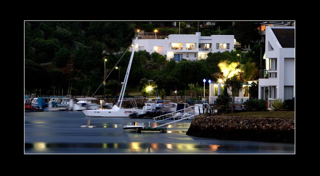 a sailboat is docked in a marina at night at Dockside in Port Alfred