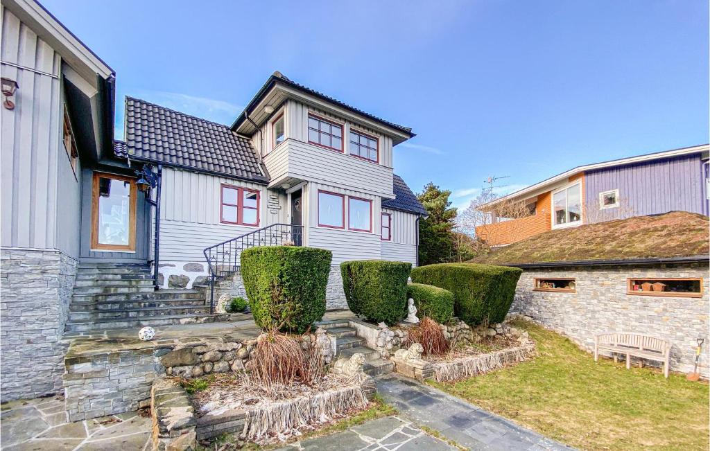 una casa bianca con delle siepi davanti di 3 Bedroom Beautiful Home In Hovs a Hovås