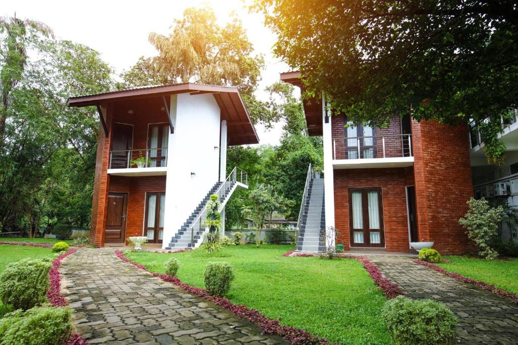 a brick house with a staircase leading up to it at Lavenro Garden in Avissawella
