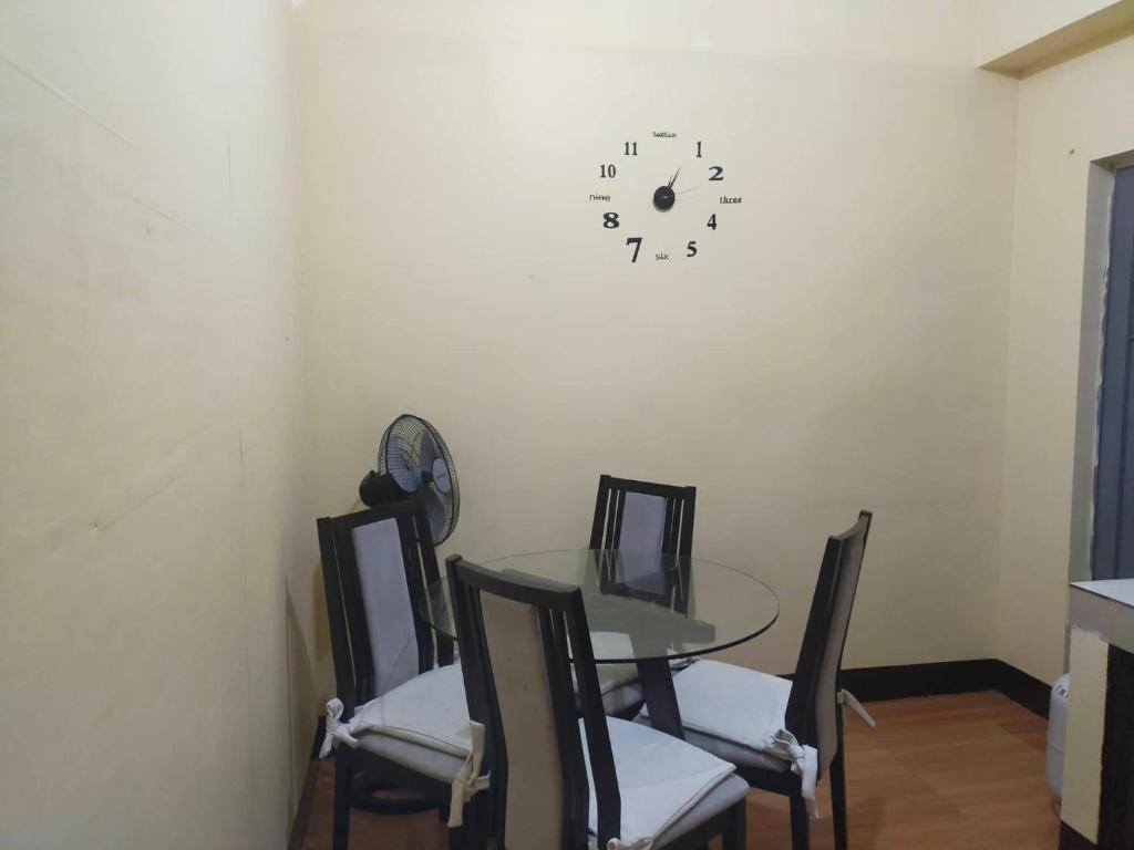 una mesa y sillas con un reloj en la pared en Vacation Station Baguio, en Baguio