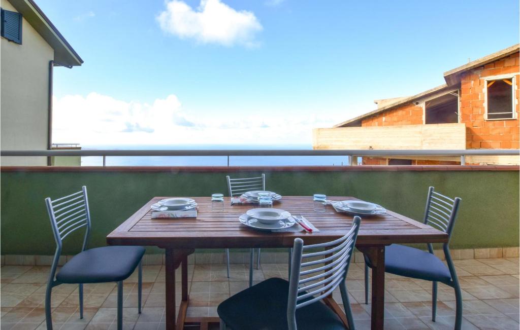 Une table et des chaises en bois sont disponibles sur la terrasse. dans l'établissement Cozy Apartment In Piraino With House Sea View, à Piraino