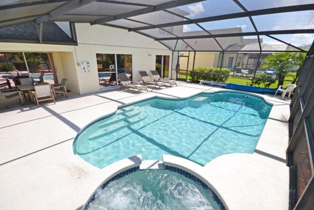 a swimming pool in a house with a patio at Ainsdale Haven home in Kissimmee