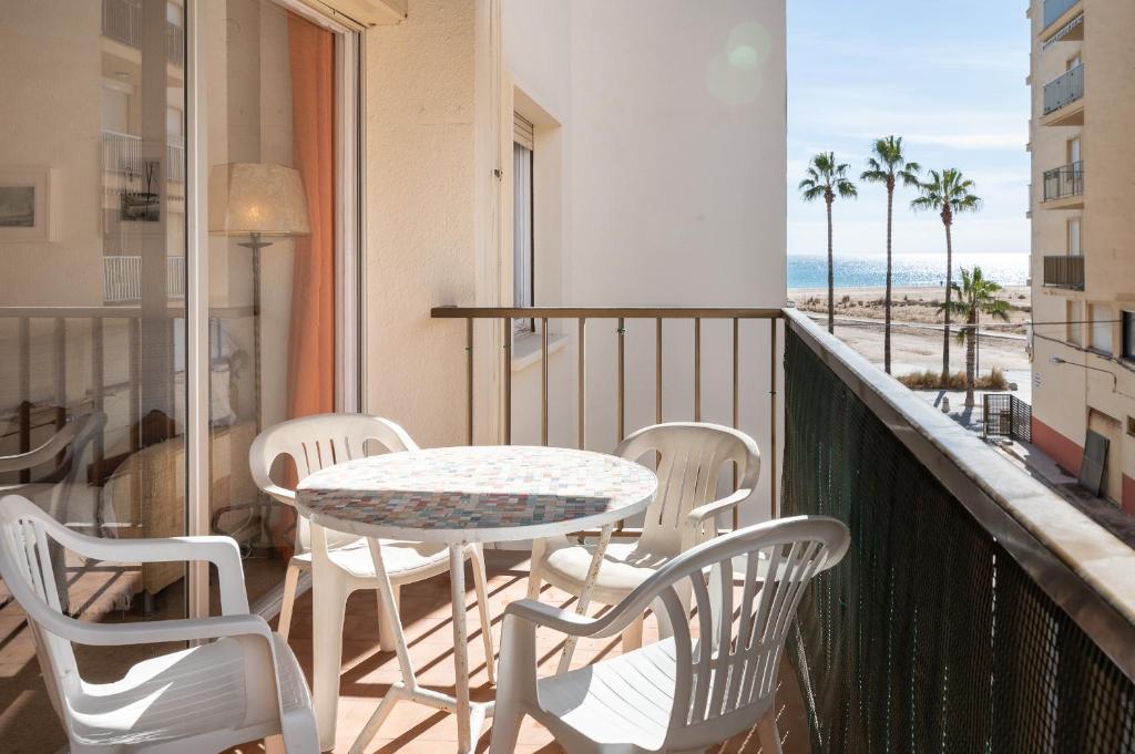 einen Balkon mit Tisch und Stühlen sowie Strand in der Unterkunft AT129 Torremar II in Torredembarra