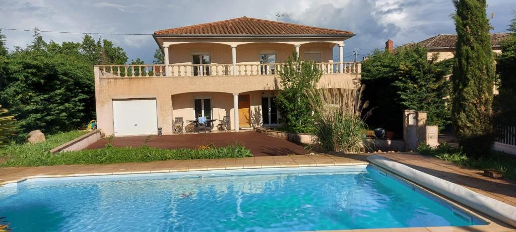une villa avec une piscine en face d'une maison dans l'établissement Maison 5 chambres et piscine, à Charnay-lès-Mâcon
